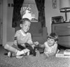 Two boys playing with toy game on living room floor Poster Print - Item # VARSAL255420921