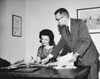 Businesswoman checking documents with a businessman standing beside her Poster Print - Item # VARSAL25548755