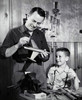 Father repairing a model airplane with his son standing beside him Poster Print - Item # VARSAL25519648