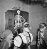 Young woman attempting to bite apple while two boys are watching during Halloween Poster Print - Item # VARSAL255424316