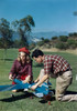 Teenage boy and a teenage girl repairing a model airplane in a park Poster Print - Item # VARSAL380720857