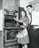 Mid adult couple standing near an oven and smiling Poster Print - Item # VARSAL25541308
