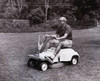 Side profile of a senior man riding a mower in a garden Poster Print - Item # VARSAL25511090