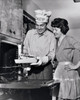 Mid adult man taking food out of an oven with a mid adult woman standing beside him Poster Print - Item # VARSAL25536216