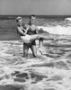 Young man carrying young woman in water Poster Print - Item # VARSAL2556618
