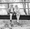 Teenage couple sitting on footbridge  doing homework Poster Print - Item # VARSAL255417671