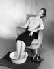 Young woman sitting with her feet soaked in a basin of water Poster Print - Item # VARSAL2552870