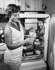 Side profile of a young woman standing near a refrigerator pouring milk Poster Print - Item # VARSAL2554791