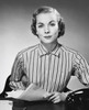Portrait of a businesswoman sitting at a desk and holding documents in an office Poster Print - Item # VARSAL25548459
