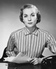 Portrait of a businesswoman sitting at a desk and holding documents in an office Poster Print - Item # VARSAL25548459