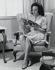 Young woman sitting on an armchair reading a magazine Poster Print - Item # VARSAL25541874