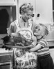 Mid adult woman holding a roast turkey with her son hugging her Poster Print - Item # VARSAL25519578D