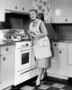 Young woman cooking in the kitchen and smiling Poster Print - Item # VARSAL25536208