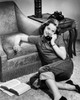 Teenage girl leaning against an armchair and talking on the telephone Poster Print - Item # VARSAL2554865B