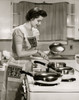 Side profile of a young woman cooking food in the kitchen Poster Print - Item # VARSAL2553334