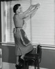 Side profile of a young woman cleaning window blinds Poster Print - Item # VARSAL255395