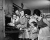 Teenage girl putting a turkey into an oven with her family standing beside her Poster Print - Item # VARSAL25535516