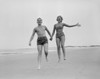 Exhilarated young couple running on sandy beach Poster Print - Item # VARSAL255416334
