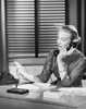 Businesswoman talking on the telephone and reading a document in an office Poster Print - Item # VARSAL25535402