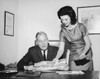 Businessman looking at a map with his secretary standing beside him Poster Print - Item # VARSAL25548762