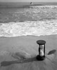 1960s Still Life Of Hourglass At Edge Of Beach Sand With Waves Washing Up On Shore And Power Boat Passing Offshore - Item # PPI179142LARGE