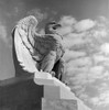 1960s Eagle Statue Against Sky Clouds Wings Spread Feathers Talons Curled Over Edge Of Base Philadelphia 30Th Street - Item # PPI179365LARGE