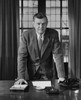 Businessman leaning against a desk in an office Poster Print - Item # VARSAL25548333