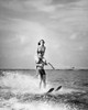 Young man waterskiing in sea with young woman sitting on his shoulders Poster Print - Item # VARSAL255339