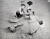 High angle view of a brother and his sister burying their father on the beach Poster Print - Item # VARSAL255512