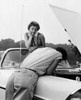 Rear view of a young man examining his car with a young woman looking at him Poster Print - Item # VARSAL2555557