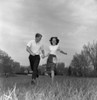 Young couple running through field Poster Print - Item # VARSAL255418153