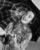 Close-up of a young woman holding an umbrella and smiling Poster Print - Item # VARSAL25514910