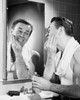 Young man applying aftershave to his face Poster Print - Item # VARSAL25527360