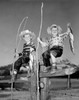 Portrait of two boys with bunch of fish and fishing rods made of sticks sitting on wooden fence Poster Print - Item # VARSAL2556630