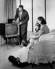 Parents with their two children sitting in front of television Poster Print - Item # VARSAL2551039