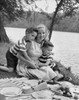 Mid adult woman picnicking with her two sons at a riverbank Poster Print - Item # VARSAL2554670B