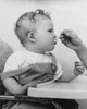 Close-up of a person's hand feeding a baby sitting in a high chair Poster Print - Item # VARSAL2559691
