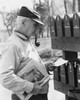 Senior man reading mail near mailboxes Poster Print