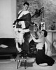 Side profile of a mid adult man standing with a mid adult woman stitching his costume Poster Print - Item # VARSAL255665