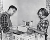 Teenage couple cooking hamburgers on a stove Poster Print - Item # VARSAL25541389