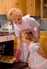 Mid adult woman putting cookies in an oven with her daughter standing beside her Poster Print - Item # VARSAL9592583