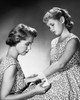 Studio shot of mother applying bandage around daughter's wrist Poster Print - Item # VARSAL25529092