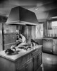 Side profile of a young woman sitting on a chair in the kitchen Poster Print - Item # VARSAL25531918