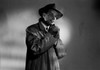 Portrait of young man wearing coat and hat and smoking cigarette  studio shot Poster Print - Item # VARSAL255419913