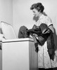 Side profile of a young woman putting clothes into a washing machine Poster Print - Item # VARSAL25541821