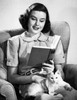 Mid adult woman reading a book with a cat sitting on her lap Poster Print - Item # VARSAL25527919