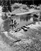 Vintage photograph of boy and girl on wooden raft  fly-fishing with improvised fishing rods in stream Poster Print - Item # VARSAL25516348