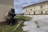 January 24, 2006 - A Marine posts security as a team of Marines prepare to enter a simulated enemy warehouse during a HELO Raid exercise in the jungles of Guam. Poster Print - Item # VARPSTSTK102156M