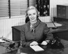 Portrait of a businesswoman sitting at a desk and smiling in an office Poster Print - Item # VARSAL25539183