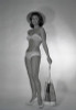 Mid adult woman wearing bikini and straw hat holding beach bag Poster Print - Item # VARSAL255418004